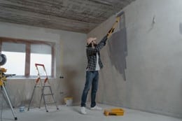 A man is painting a wall