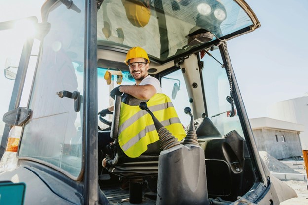 construction worker sitting in cab of loader equipment