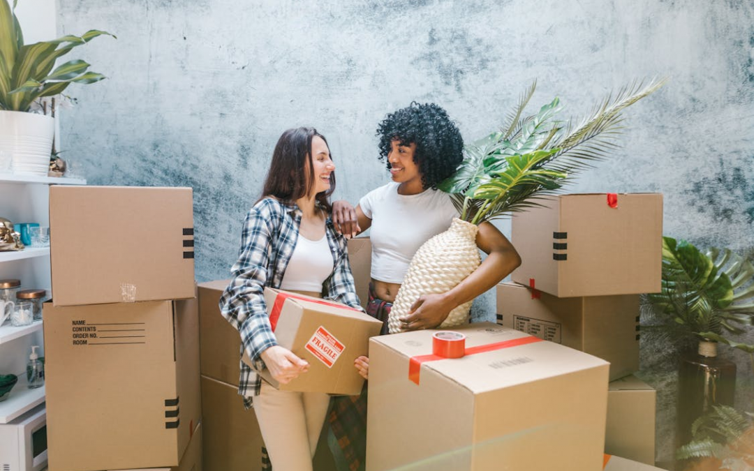 two women packing moving boxes