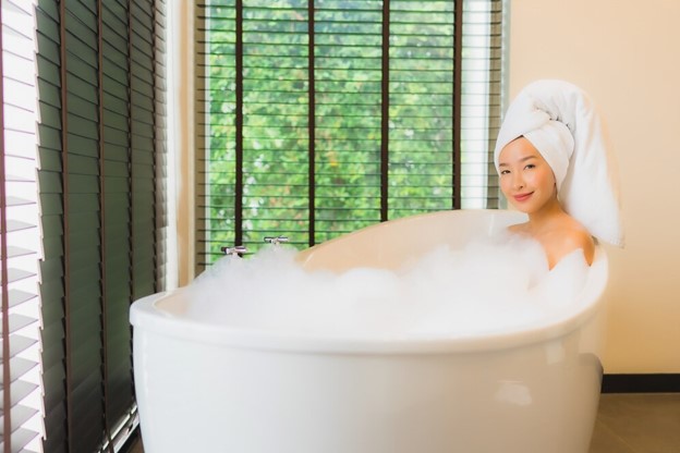 asian woman soaking in a white tub