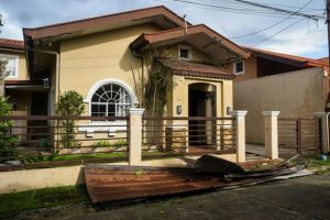 yellow house with metal fence