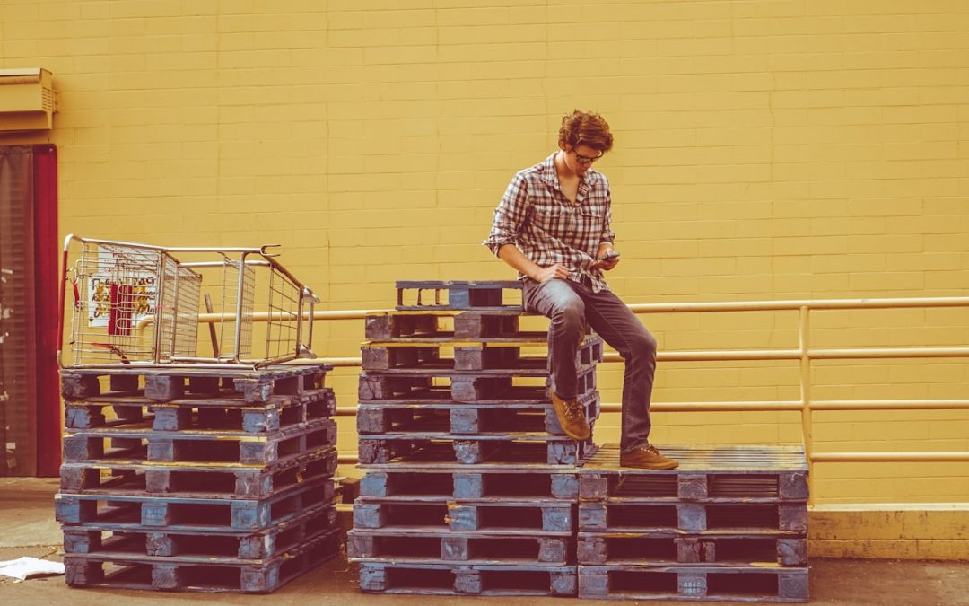 man sitting on a stack of pallets