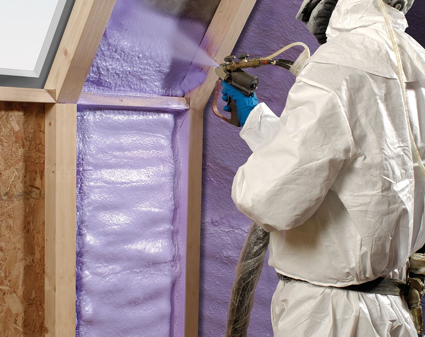 man in safety suit spraying foam insulation