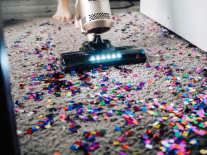 vacuuming colorful papers off carpet