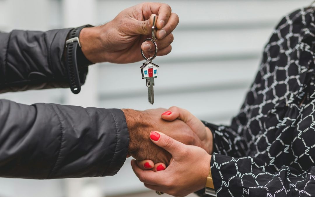 two people shaking hands and giving set of keys