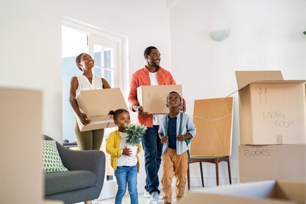 family carrying moving boxes