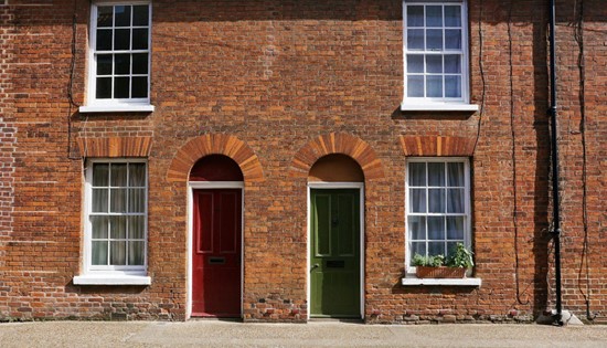 brick sided building with two colorful entry doors