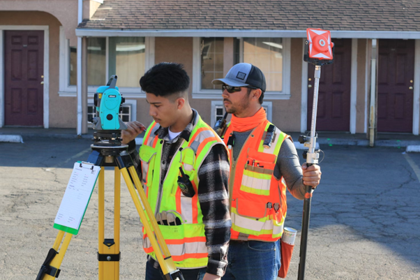 men sith survey equipment on jobsite