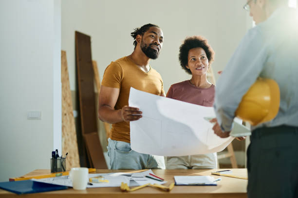 young couple talking with contractor looking at plans