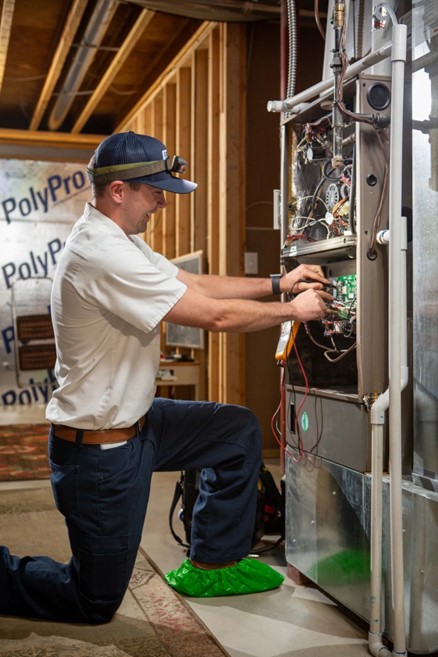 furnace and heating repair man working on furnace