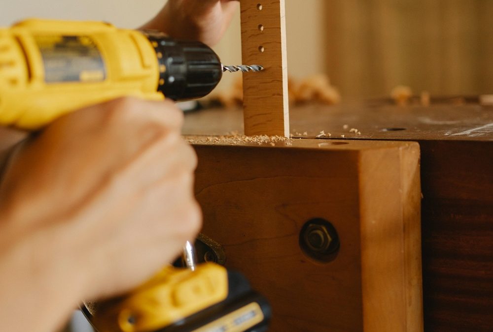 person using screw driver gun on wood project