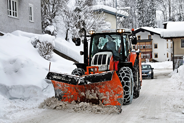 tractor with plow removing snow