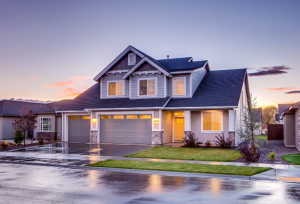 street wet with rain and house with lights on