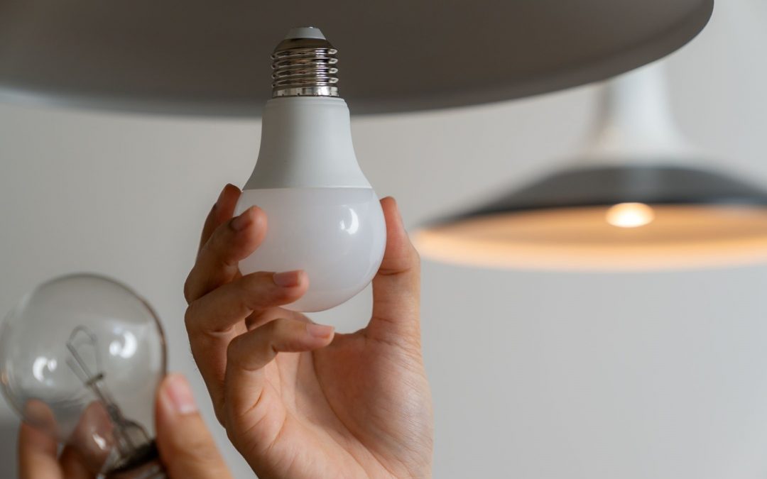 hand screwing in light bulb