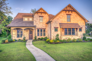 brick house with green lawn and walkway to front door