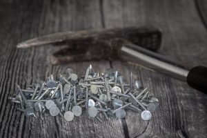 many nails and a hammer on wood