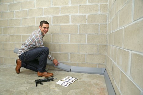 man working on waterproofing basement