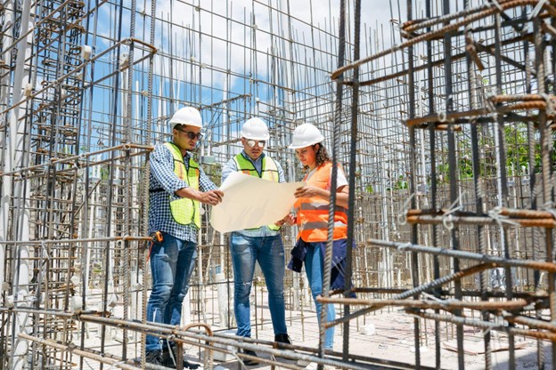 contractors on job site discussing blue prints