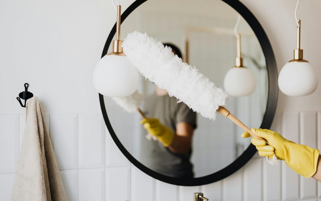 cleaner using gloves and dusting tool to clean fixtures