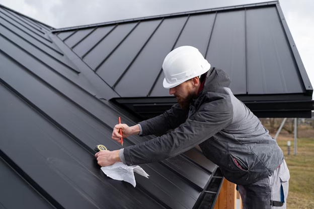 roofer on roof doing measurements