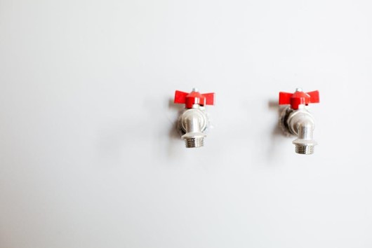 two faucets mounted on wall