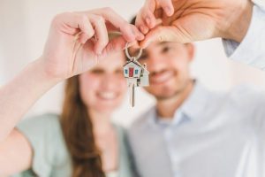 Young couple holding keys to new home