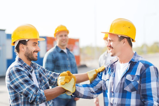 construction workers shaking hands on job site