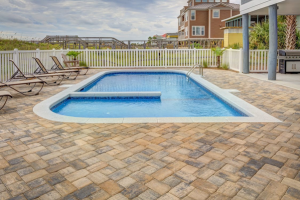 built in pool with deck made of paver stones