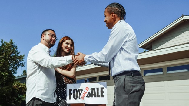 agent congratualting young couple on new home