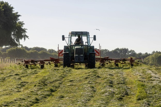 farmer using tractor to spread seeds