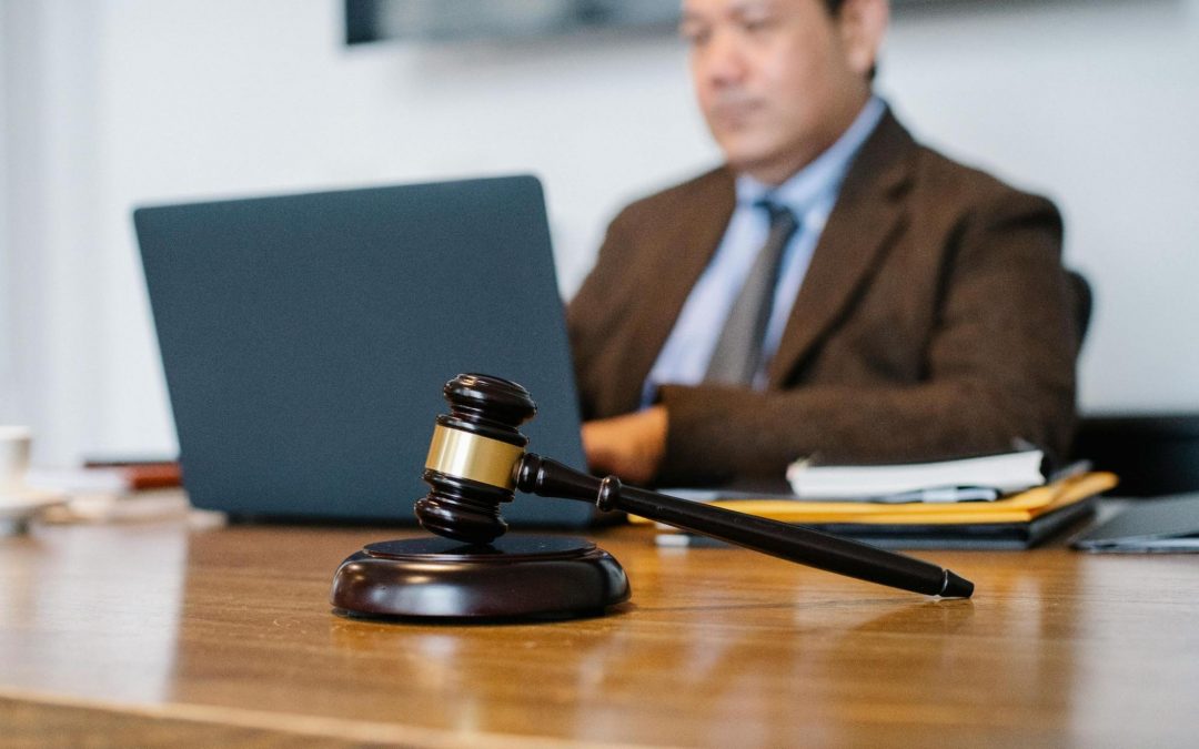 judge working at his desk with a gavel in focus in front of him