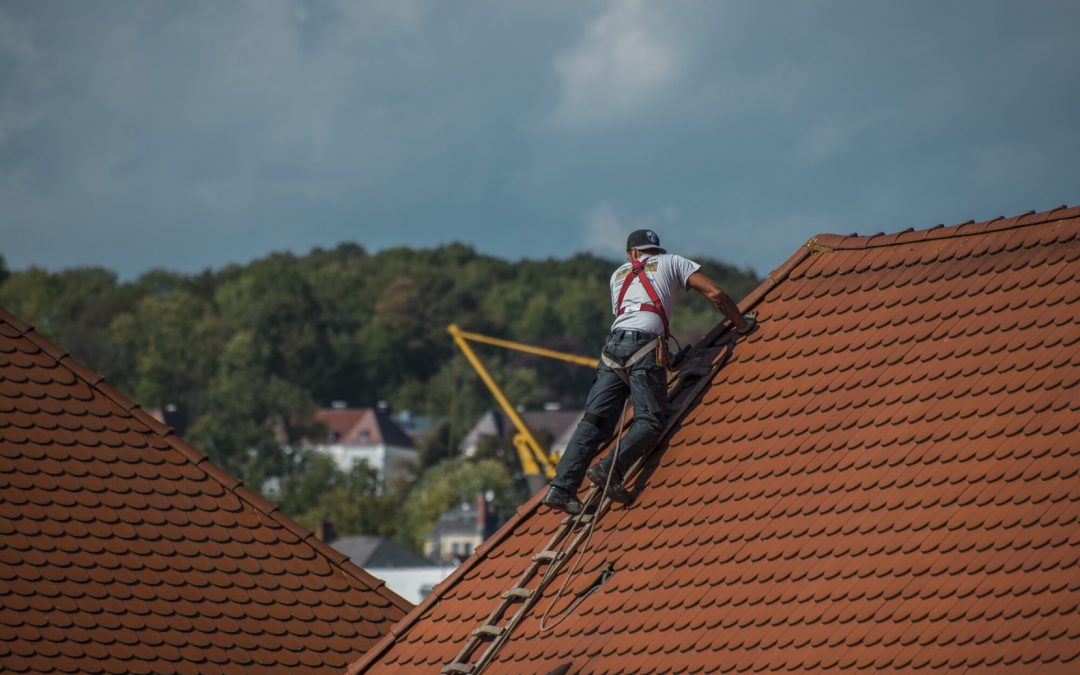 man on roof making repairs