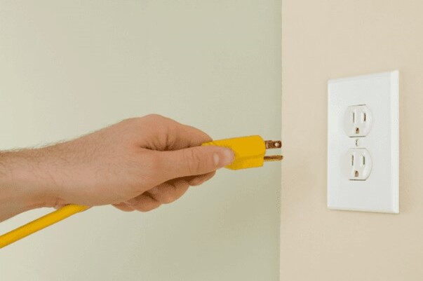 pluggin yellow extension cord into wall outlet