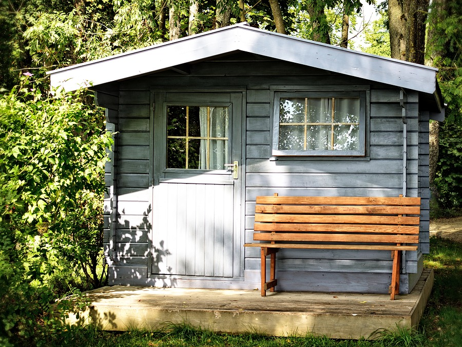 prefab shed with door window and bench. looks like a very tiny house.