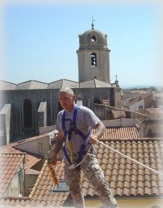 roofer wearing personal protective equipment on top of roof for fall protection