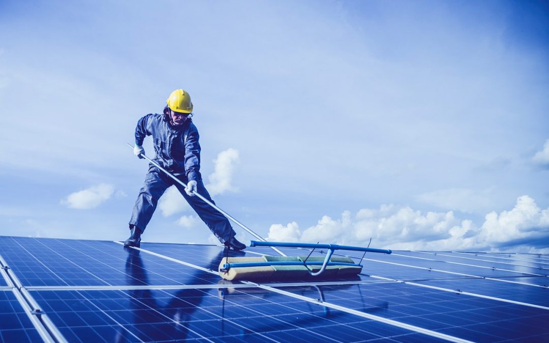 worker cleaning solar panels