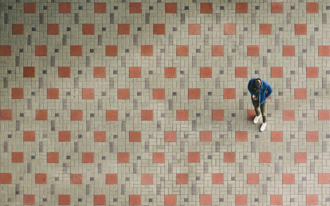 downward photo of a man standing on tile