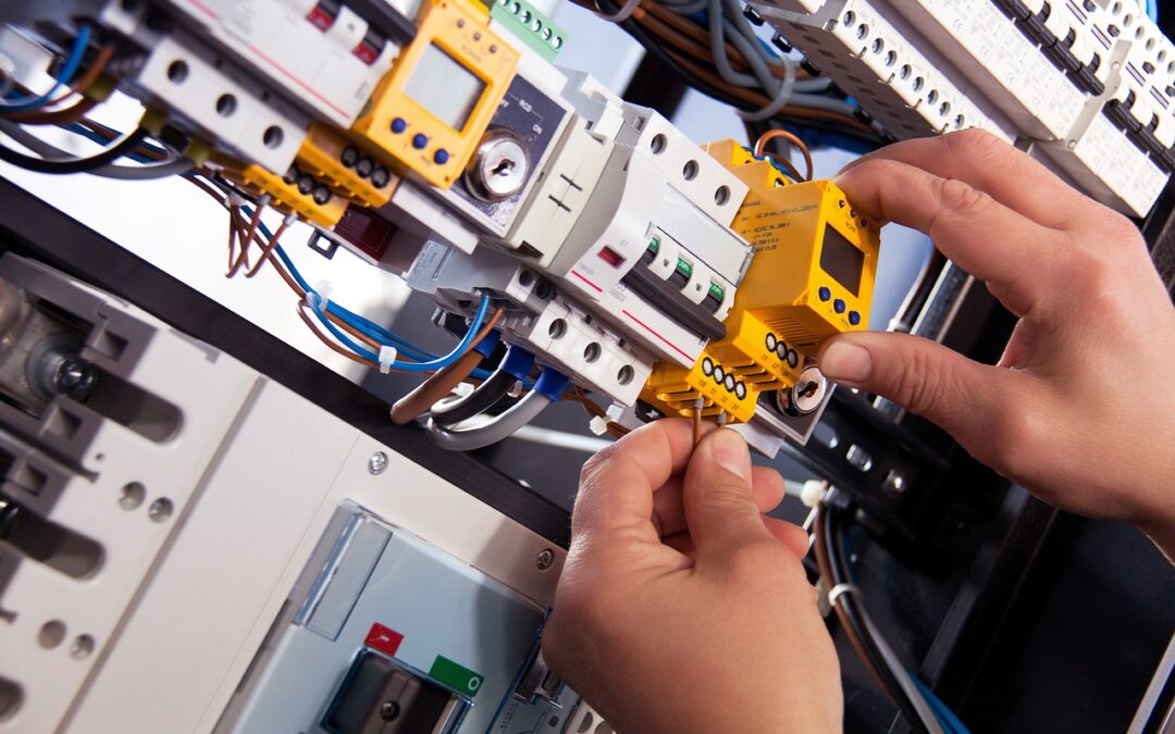 hands working on electronic panel