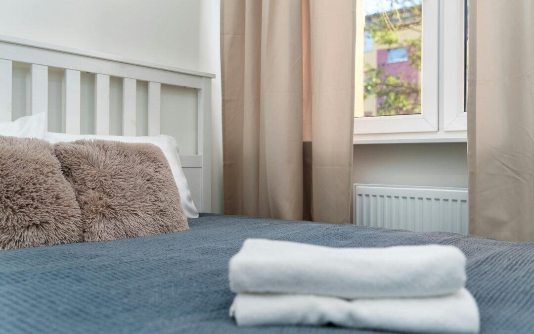 A neatly made bed with fresh linens and folded towels