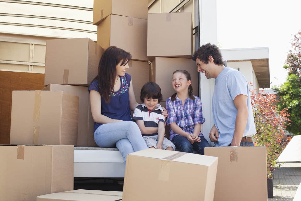 Family sitting on back of moving van