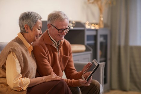 older couple looking at table older couple looking at computer tablet together