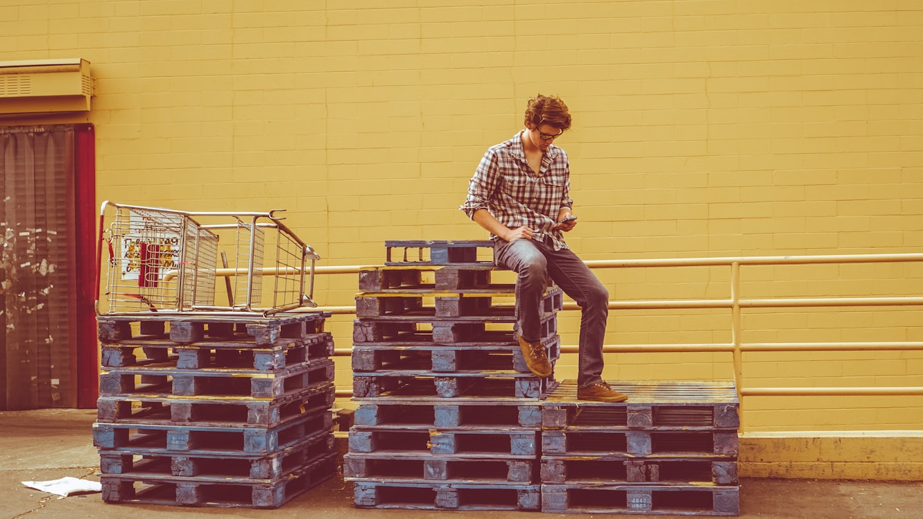 stacks of pallets man sitting on a stack of pallets