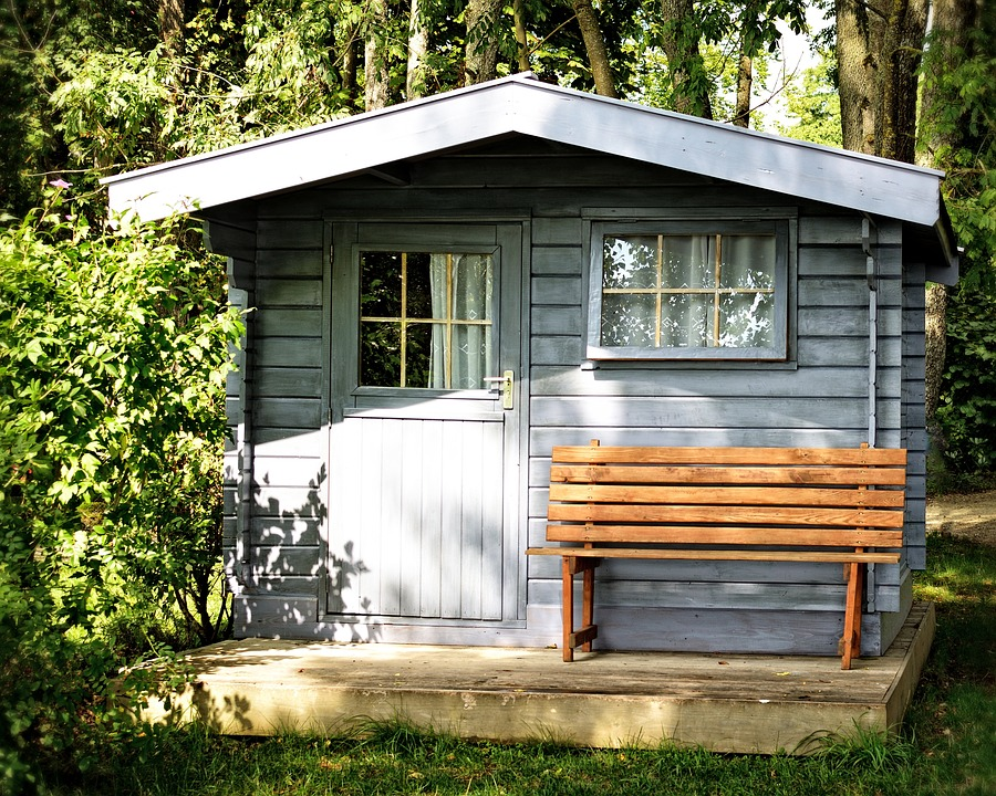 prefab shed with door window and bench. looks like a very tiny house.