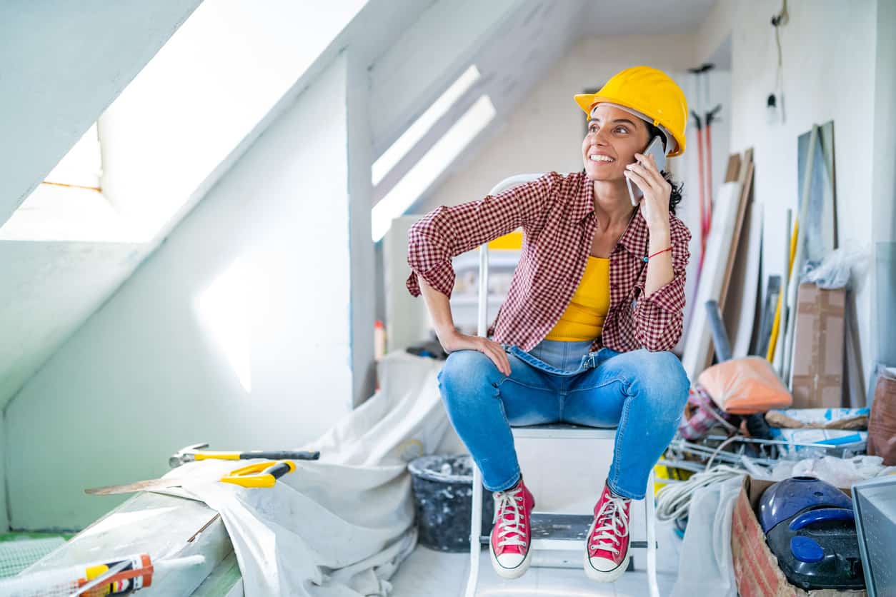 Mid adult women enjoying home renovation and talking on a smart phone