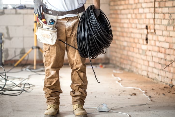 Electrician with tools, working on a construction site. Repair and handyman concept.