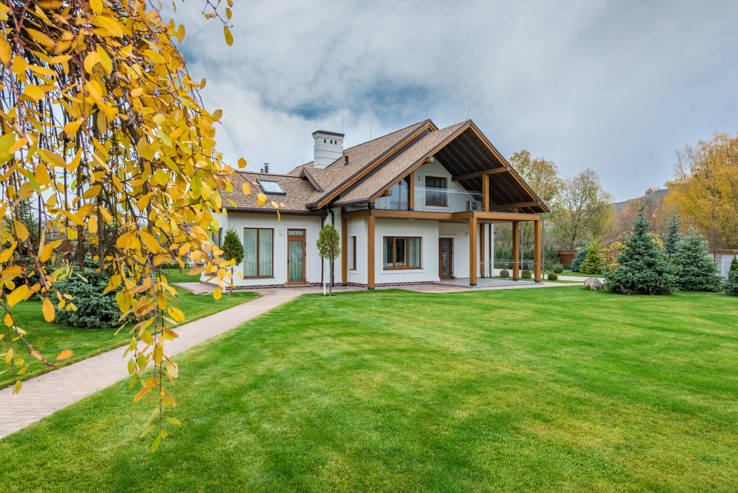white-house-with-wood-trim home with beatiful landscaping